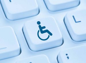A blue wheelchair accessibility symbol appears on a single keyboard key among surrounding white keys.