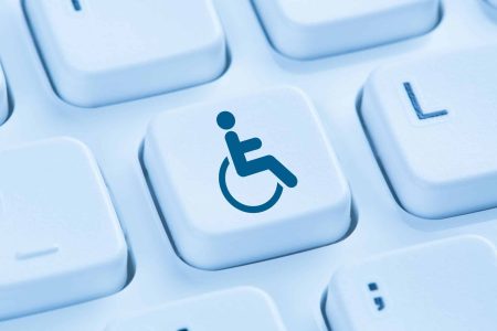 A blue wheelchair accessibility symbol appears on a single keyboard key among surrounding white keys.