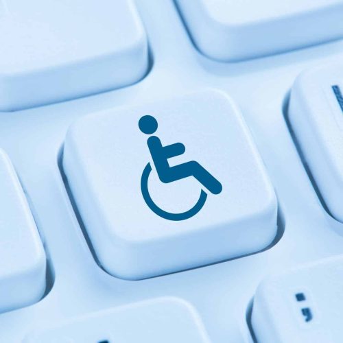 A blue wheelchair accessibility symbol appears on a single keyboard key among surrounding white keys.