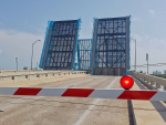 A double drawbridge opened up with the barrier gate down and the red  light lit