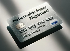 A silver credit card lying flat on a plain surface, The numbers are flat, and blend into the background, making them very difficult to read. Sunlight streams in from a nearby window, creating a strong natural lighting effect with extremely bright highlights and soft shadows on the card and surface. The words Nationwide Select Nightmare! are printed on the card.