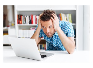 A web designer with his head in his heads, staring at his laptop