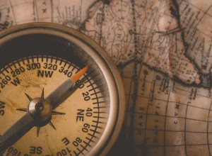 an old compass on top of an old map of the world