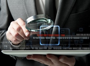 Close-up of a man in a suit holding a magnifying glass over a computer tablet with binary digits overlaid across the image