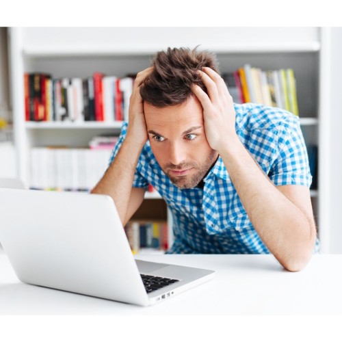 A web designer with his head in his heads, staring at his laptop