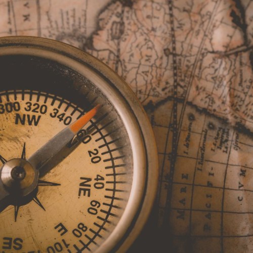 an old compass on top of an old map of the world