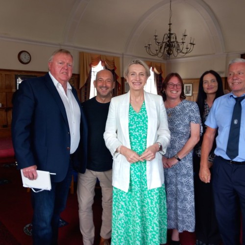 Littlehampton Town Council Millennium Chamber interior. John Donoghue, Clive Loseby, Alison Griffiths MP, Tina Shaw-Morton, Freya Reynolds, and Dominic Reynolds stand smiling in a group photo.