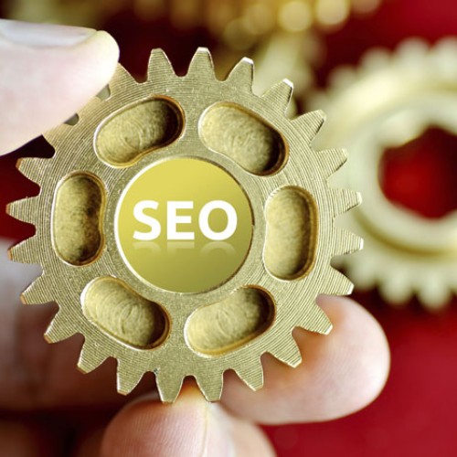 Person holding cogs spelling SEO