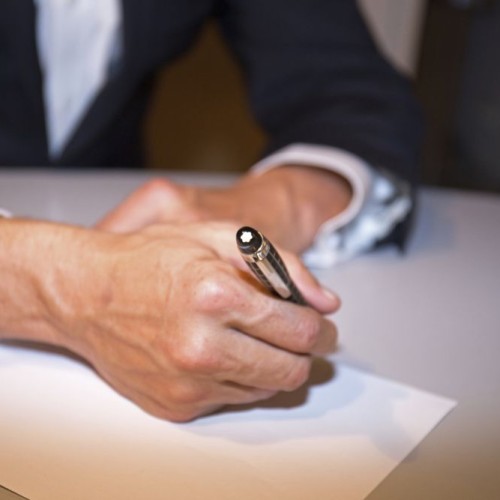 Business man writing on paper in an office