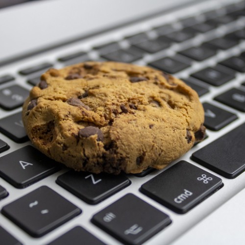 A cookie lying on a computer kewyboard