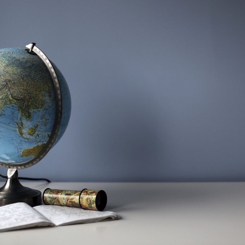 Globe and exercise book on the white student's desk