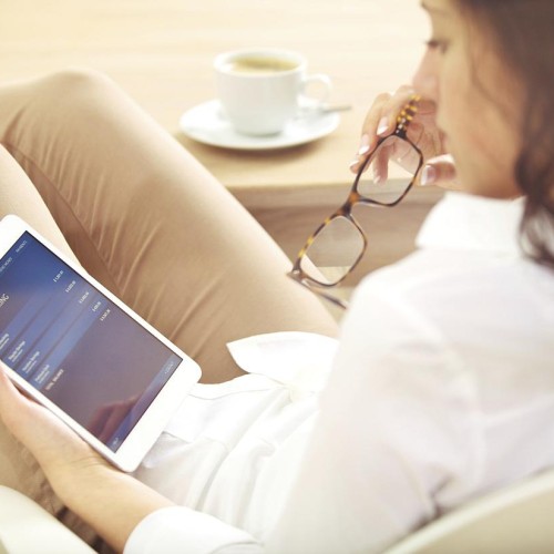 A woman sitting down holding an iPad