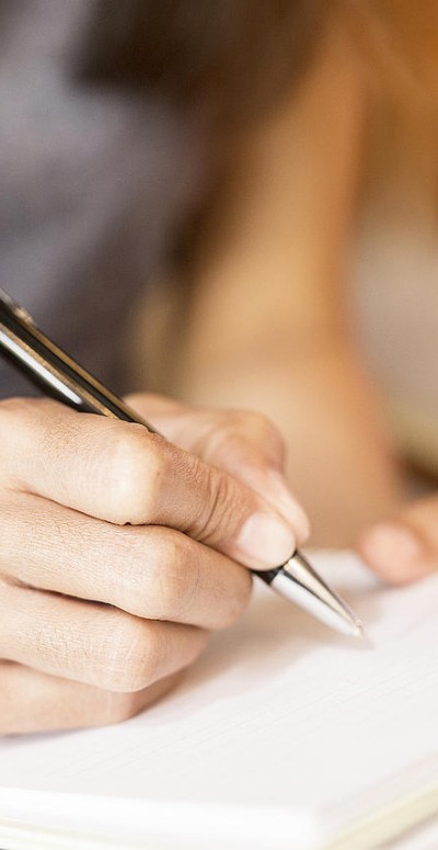 Closeup of a woman writing in a notebook