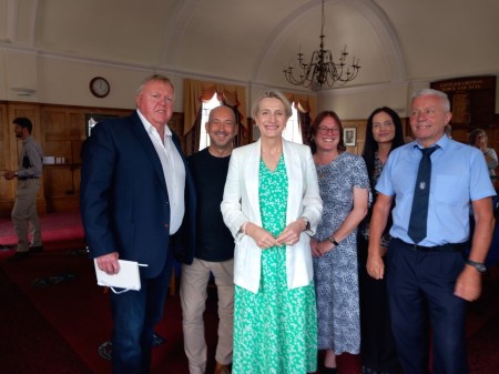 Littlehampton Town Council Millennium Chamber interior. John Donoghue, Clive Loseby, Alison Griffiths MP, Tina Shaw-Morton, Freya Reynolds, and Dominic Reynolds stand smiling in a group photo.