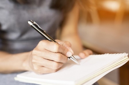 Closeup of a woman writing in a notebook