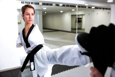 Young woman without arms training hard in martial arts