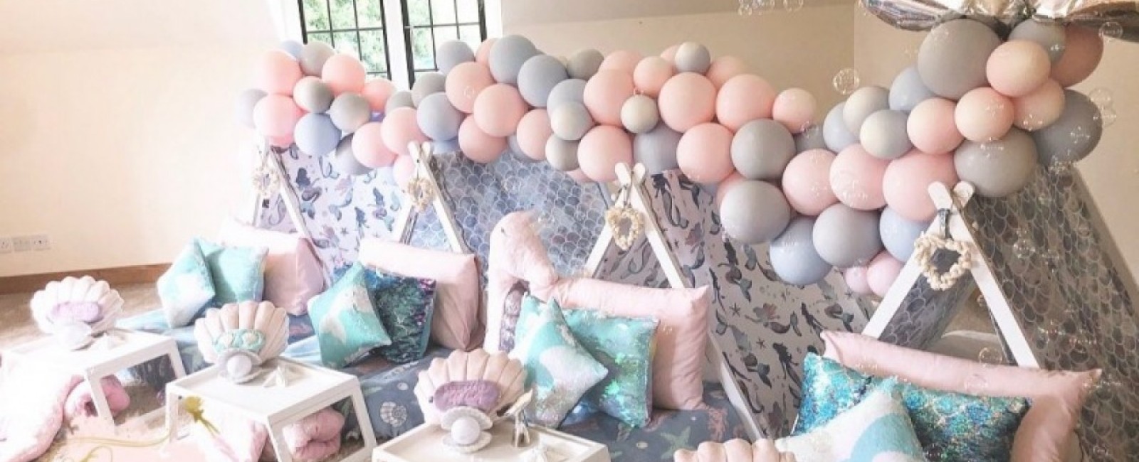Children's tents in pastel colours covered with lots of balloons