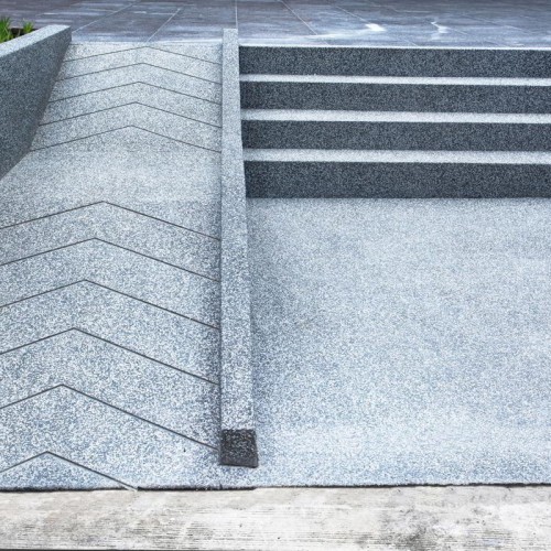 A concrete ramp next to a concrete stair on a University Campus