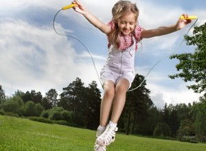 a young girl is playing with a skipping rope