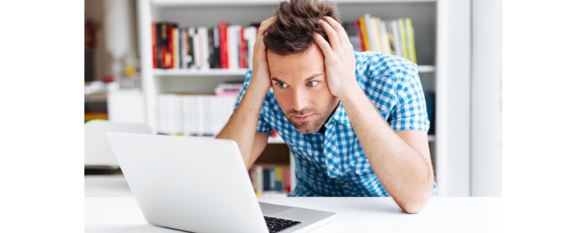 A web designer with his head in his heads, staring at his laptop