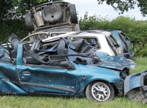 A Collection of Wrecked Cars in a Countryside Field.