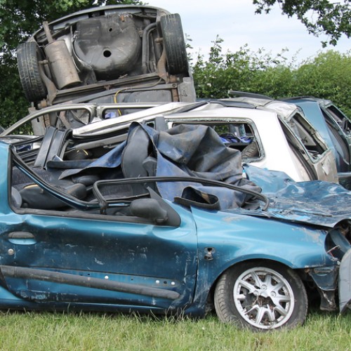 A Collection of Wrecked Cars in a Countryside Field.
