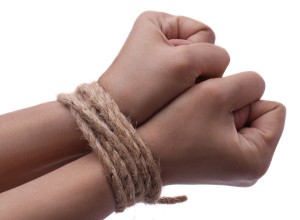 Female hands, her wrisits are tied with rope