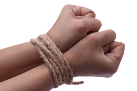 Female hands, her wrisits are tied with rope