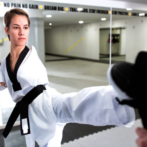 Young woman without arms training hard in martial arts