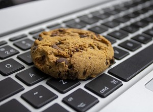 A cookie lying on a computer kewyboard
