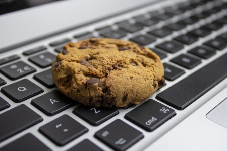 A cookie lying on a computer kewyboard