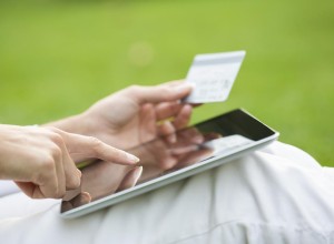 Close-up of a woman with a tablet, holding a credit card