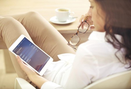 A woman sitting down holding an iPad