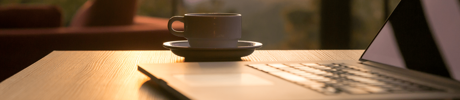 Cup of coffee next to laptop
