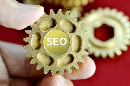 Person holding cogs spelling SEO