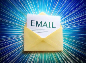 a plain text email on a piece of paper in an envelope, shown at an angle. rays of light come out from the centre