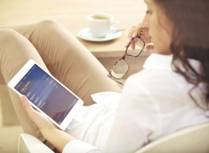 A woman sitting down holding an iPad
